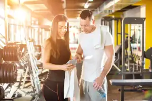 Personal trainer usando aplicativo de treino com aluno