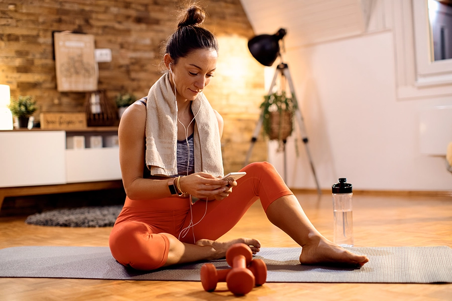 Mulher fazendo exercícios em casa usando o app PersonalGO.