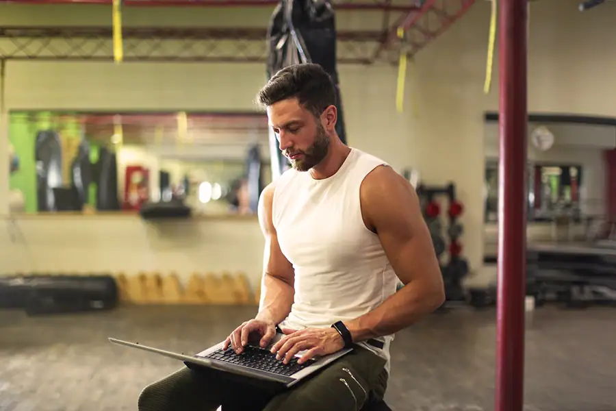 Personal trainer montando treino de musculação no celular pelo app