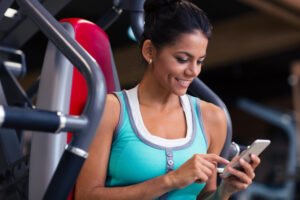 Mulher fazendo uma consultoria online com seu personal trainer pelo app.