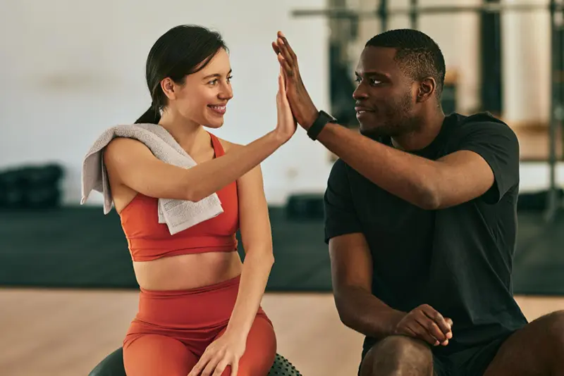 Personal trainer recebendo um sorriso de agradecimento de seu aluno no Dia do Educador Físico