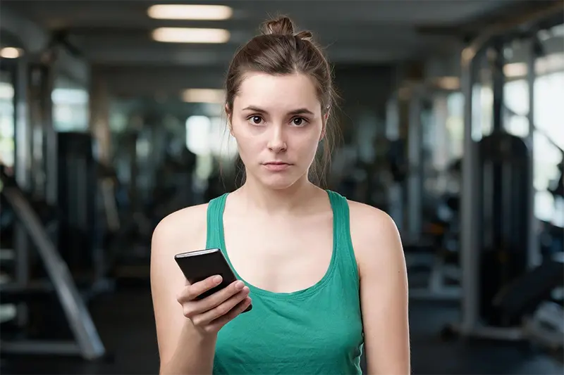 Aluno frustrado com dores após tentar montar treino de musculação online grátis pelo celular